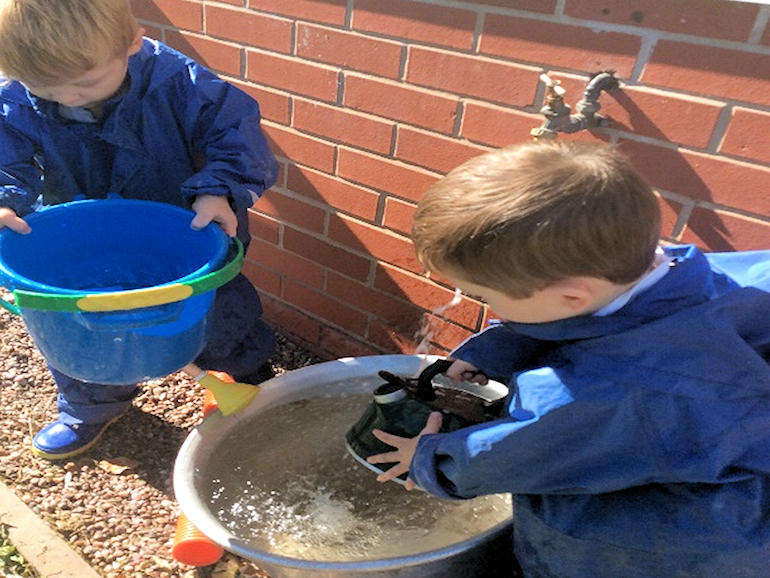 Children filling buckets of water